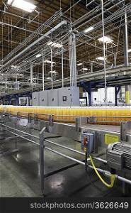 Orange juice bottles on conveyor in bottling plant