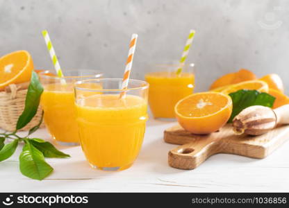 Orange juice. Freshly squeezed juice in glasses and fresh fruits with leaves