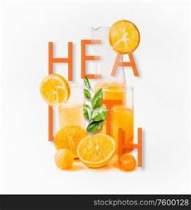 Orange juice in glasses and pitcher with fresh orange fruits slices, leaves and ice cubes with word health at white background. Healthy lifestyle concept. Summer drinks