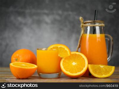 Orange juice in the glass jar and fresh orange fruit slice on wooden table / Still life glass juice on dark with copy space background