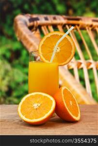 orange juice on a wooden table in the garden