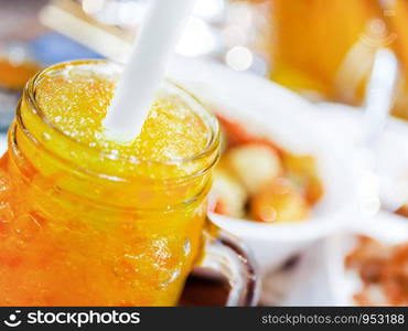 Orange juice smoothie in the glass jar with bokeh light on background.