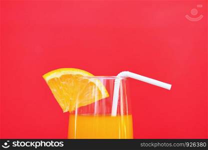Orange juice summer glass with piece orange fruit with red background