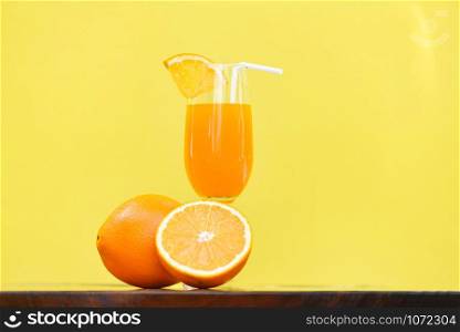 Orange juice summer glass with piece orange fruit with yellow background