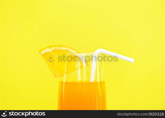 Orange juice summer glass with piece orange fruit with yellow background