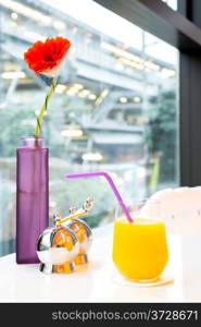 Orange juice with flower on table