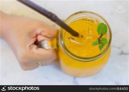 Orange juice with ice cube on marble table, stock photo
