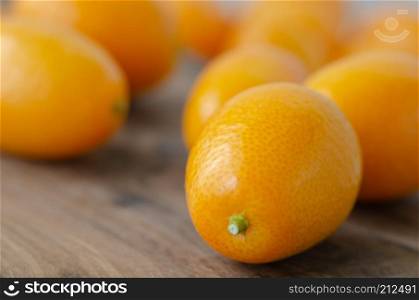 Orange kumquat fruit on wooden background