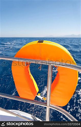 Orange lifebuoy on sailing ship and blue sea