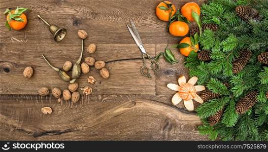 orange mandarins, walnuts and antique accessories. christmas tree branches on wooden background