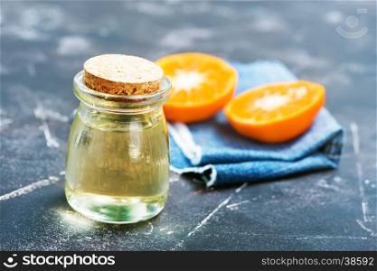 orange oil in glass bottle and on a table