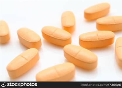 orange pills on white background