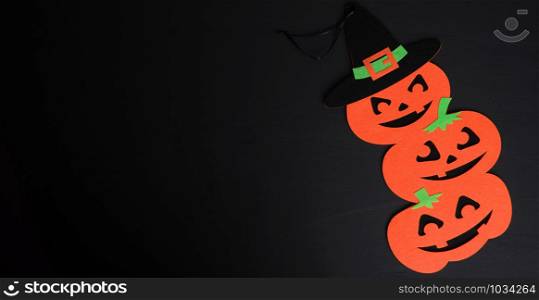 orange pumpkin felt figures on a black background, Halloween festive backdrop