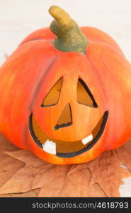 Orange pumpkin lantern with a spooky face smiling