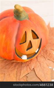 Orange pumpkin lantern with a spooky face smiling