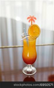 Orange - red cocktail. Tequila Sunrise cocktail on the window background