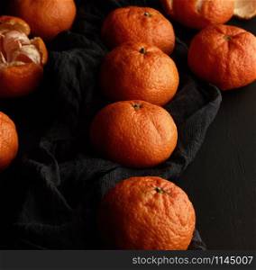 orange ripe mandarin on a black table, ripe and juicy fruits. Vegetarian healthy food, close up