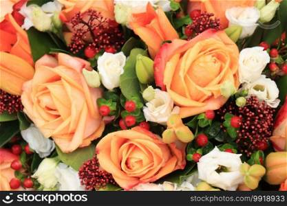 Orange roses, red berries and skimmia in a big wedding centerpiece