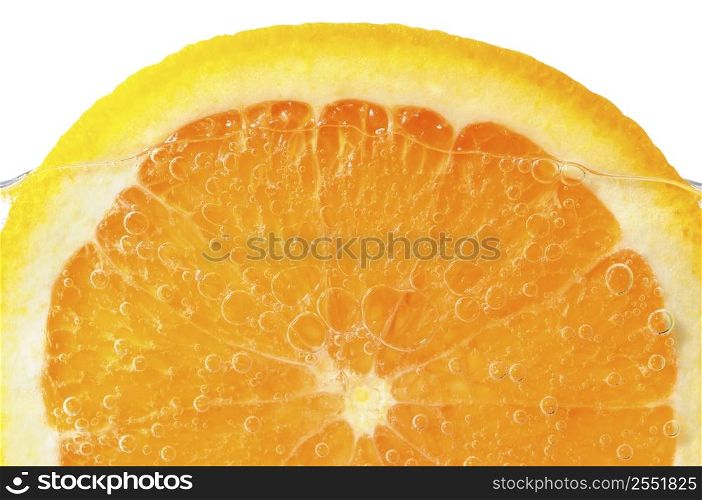 Orange slice in water with air bubbles on white background
