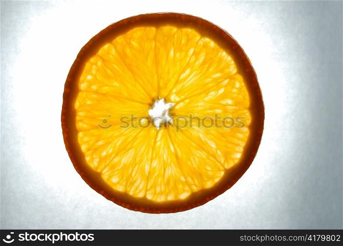 orange slice on grey background, illuminated
