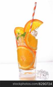 orange slices and ice cubes in cup with tube on white background