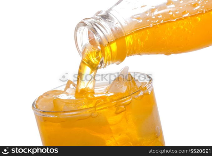 orange soda pouring into glass on white background