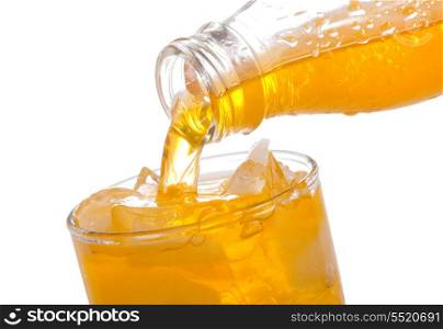 orange soda pouring into glass on white background