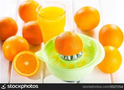 orange squeezer with fresh fruits and glass of juice