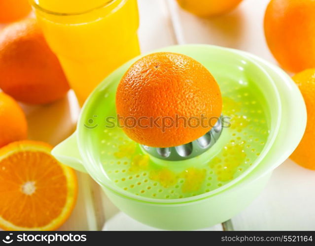 orange squeezer with fresh fruits and glass of juice