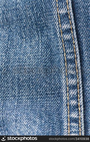 Orange stitch on the denim garment very close up.Jeans background