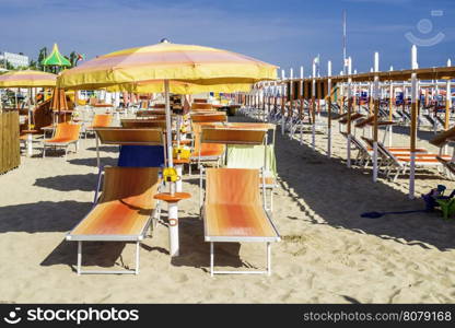 Orange sunbeds and umbrellas on the beach.