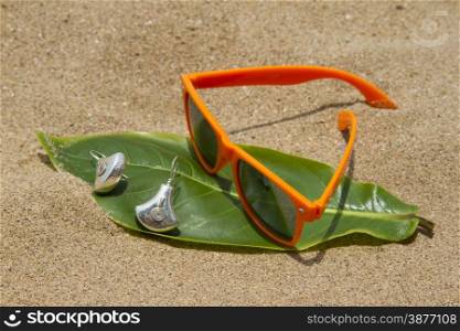 Orange sunglasses lying on the sand beach. India Goa.. Orange sunglasses lying on the sand beach. India Goa