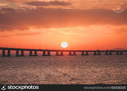 Orange sunset over the bridge silhouette. Ocean hrizon sunny landscape