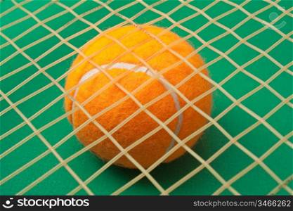 orange tennis ball on a green background