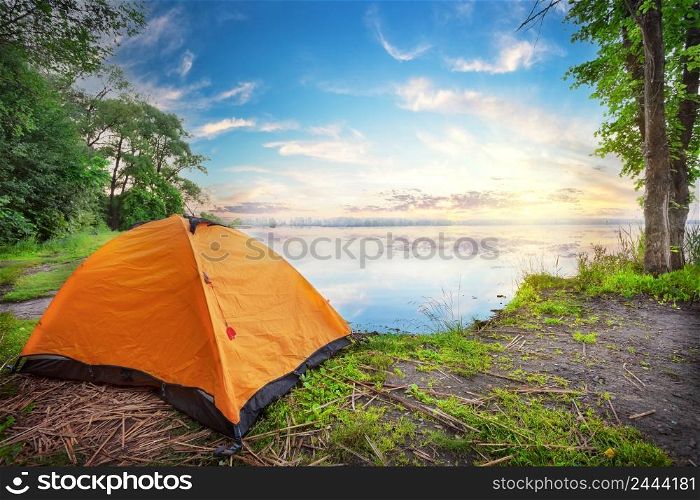 Orange tent by the lake at the sunset. Orange tent by the lake at sunset