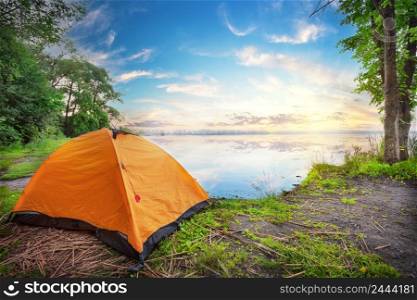 Orange tent by the lake at the sunset. Orange tent by the lake at sunset