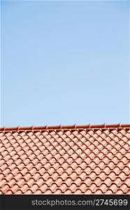 orange tiles on the roof of a house against blue sky background