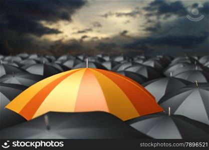 Orange umbrella in mass of black umbrellas