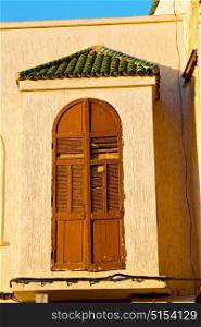 orange window in morocco africa old construction and brown wall red carpet