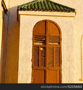 orange window in morocco africa old construction and brown wall red carpet