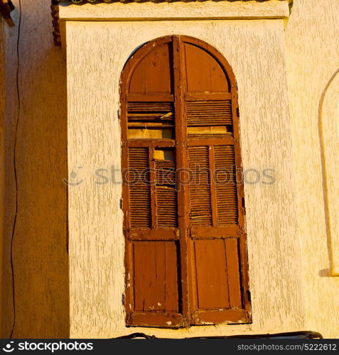 orange window in morocco africa old construction and brown wall red carpet