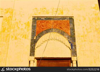 orange window in morocco africa old construction and brown wall red carpet