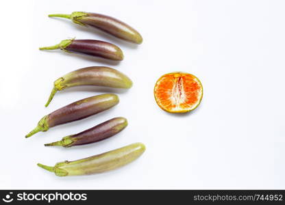Orange with eggplants on white background. Sex concept, Top view