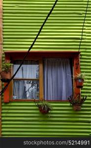 orange wood window and a green metal wall in la boca buenos aires argentina
