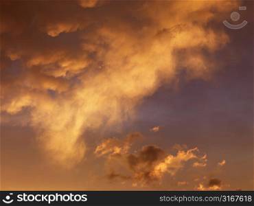 Orange-yellow clouds in sky at sunset.