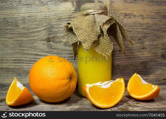 Oranges and fresh orange juice on wooden background