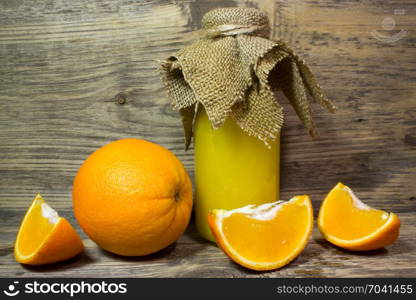 Oranges and fresh orange juice on wooden background