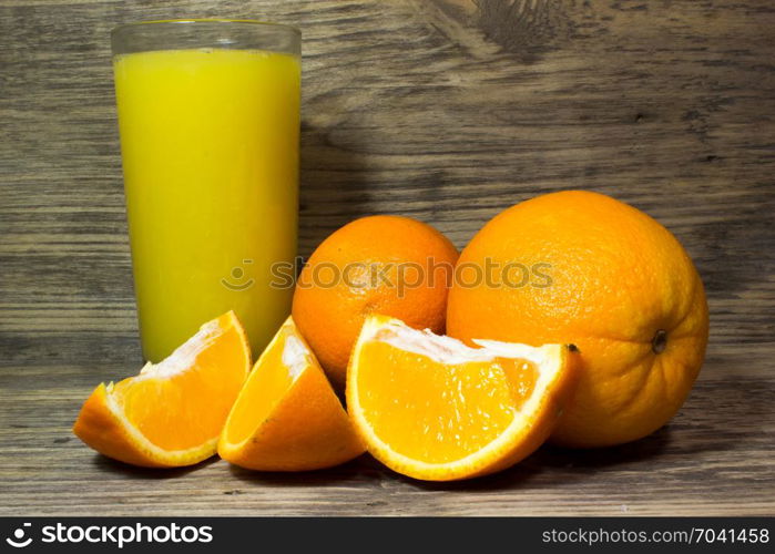 Oranges and fresh orange juice on wooden background