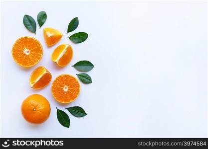 Oranges and green leaves on white background. Copy space
