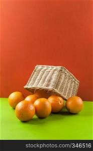 oranges in a wicker basket on colored background